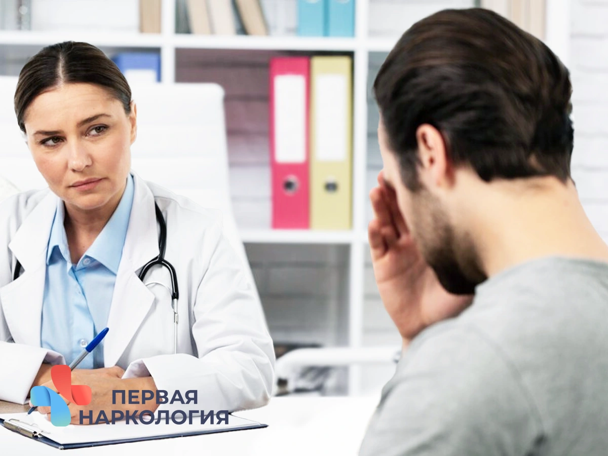 Врач сидит за столом с пациентом